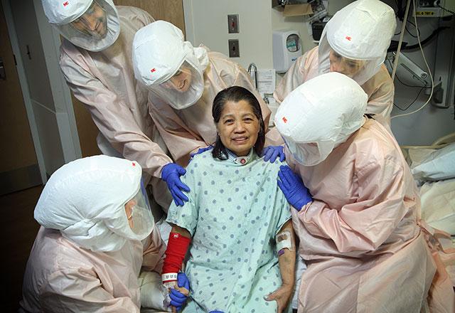 a patient surrounded by her care team in PPE
